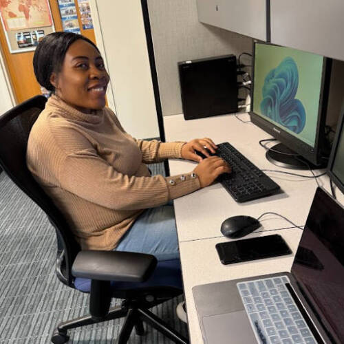Priscilla Aroboi sitting at desk